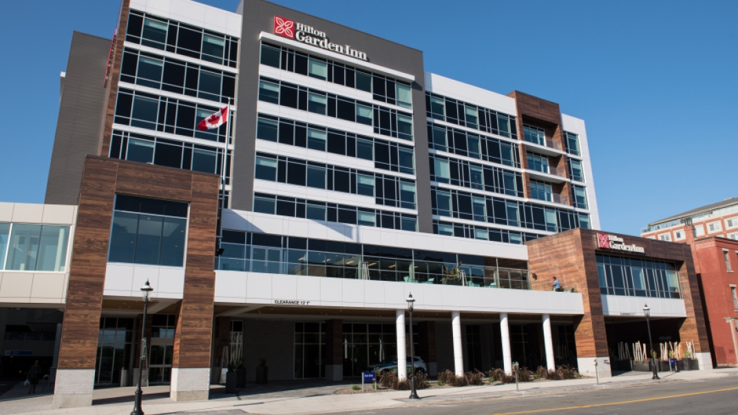 Image of the outside of the Hilton. A brown and white building.