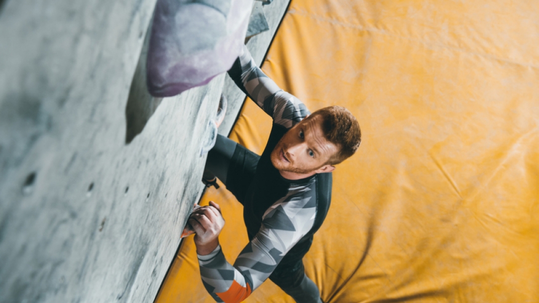 A man doing indoor rock climbing
