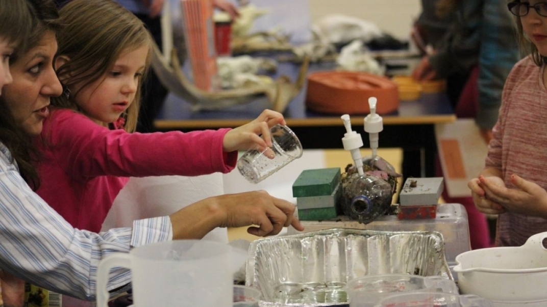 Child mixing liquids in an aluminium tray