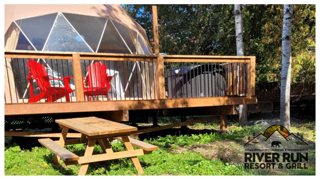 glamping tent with a deck and two bright red chairs