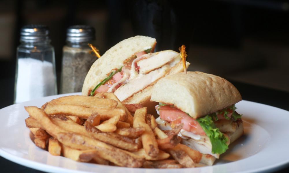 a white plate with a deli sandwich and fries