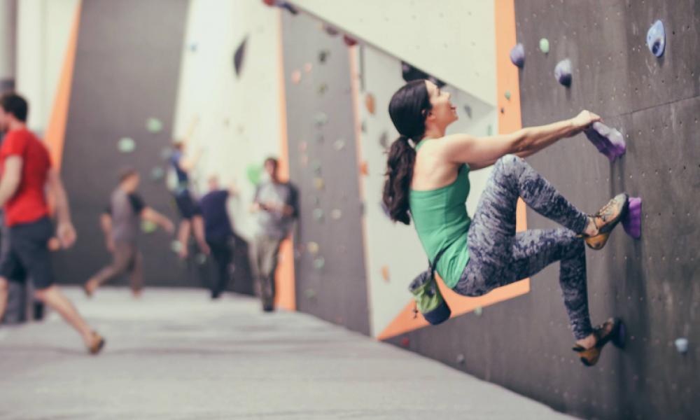 Woman in the foreground doing indoor bouldering