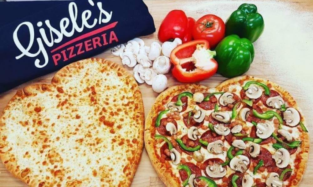two heart shaped pizzas with a gisele's shirt and some veggies
