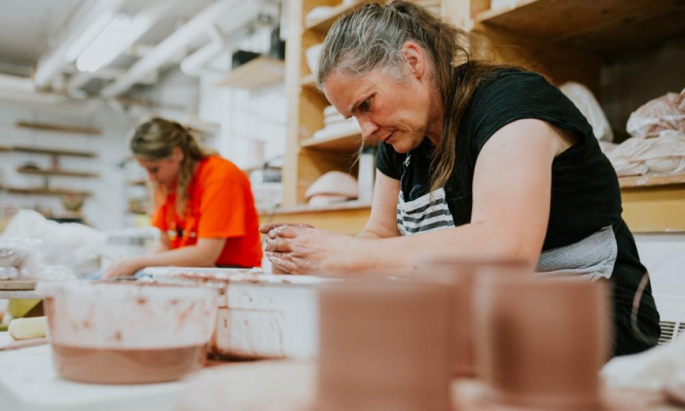 Two women in a workshop working with clay