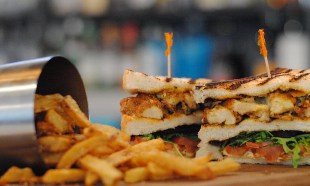 a toasted sandwich with fries and a silver fry cup