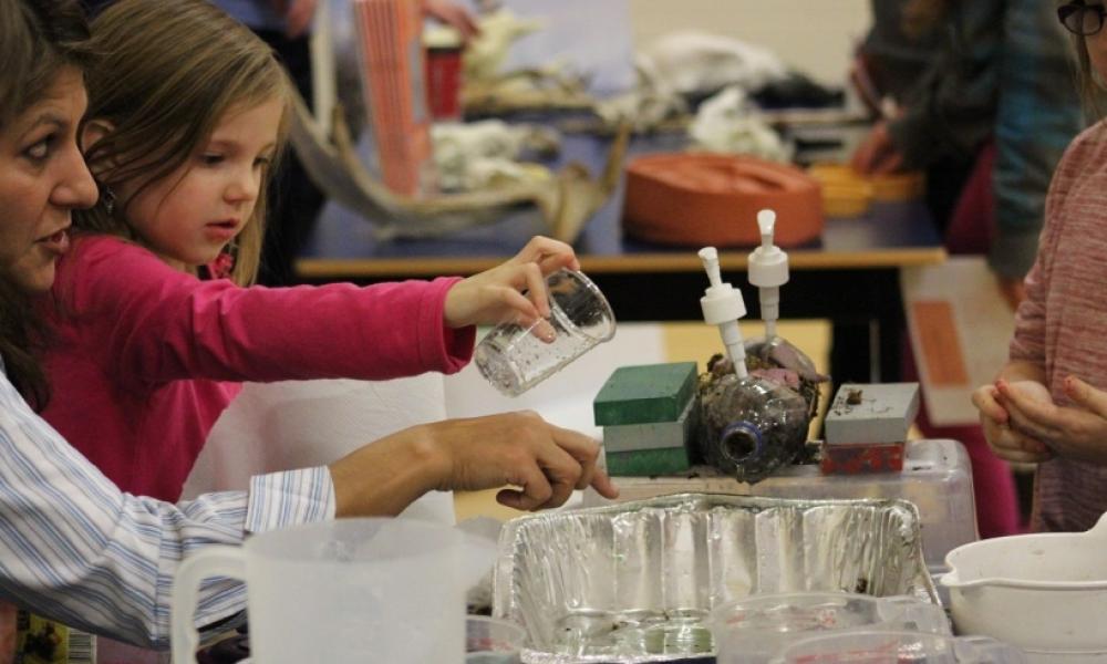 Child mixing liquids in an aluminium tray