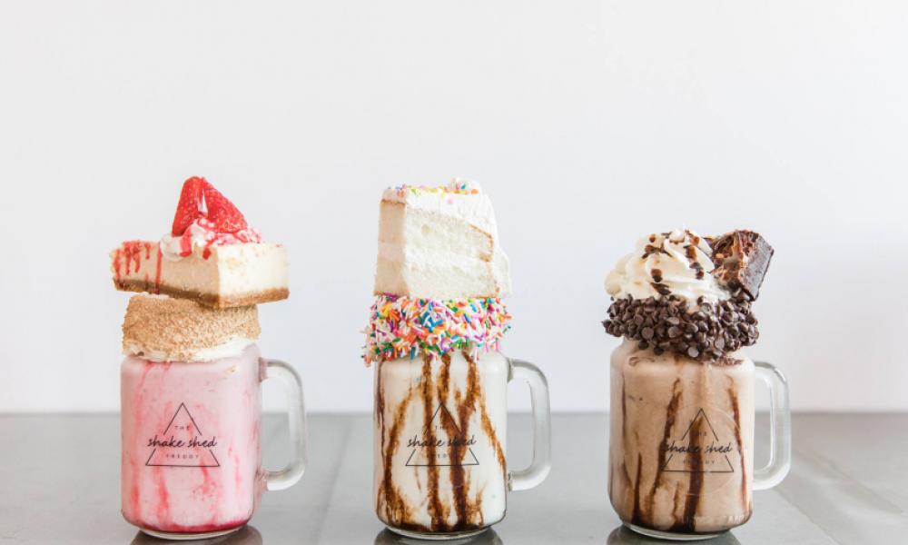 strawberry, vanilla and chocolate shakes with cake on top