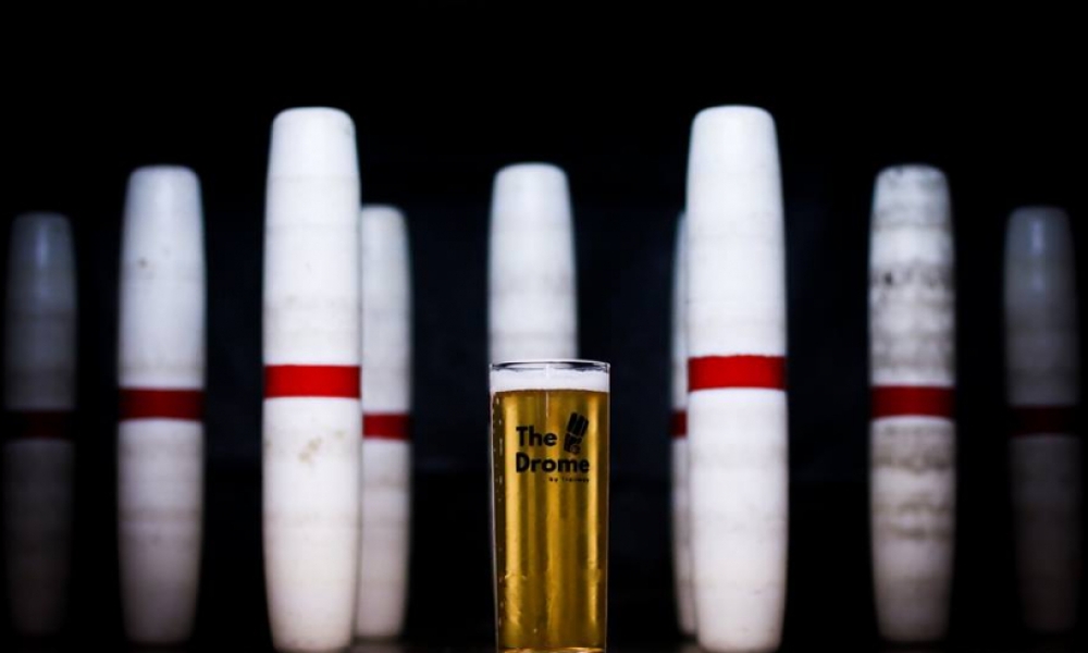 Bowling pins surrounding a pint of beer